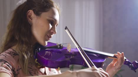 Violinist-young-woman-playing-violin-at-home,-close-up.